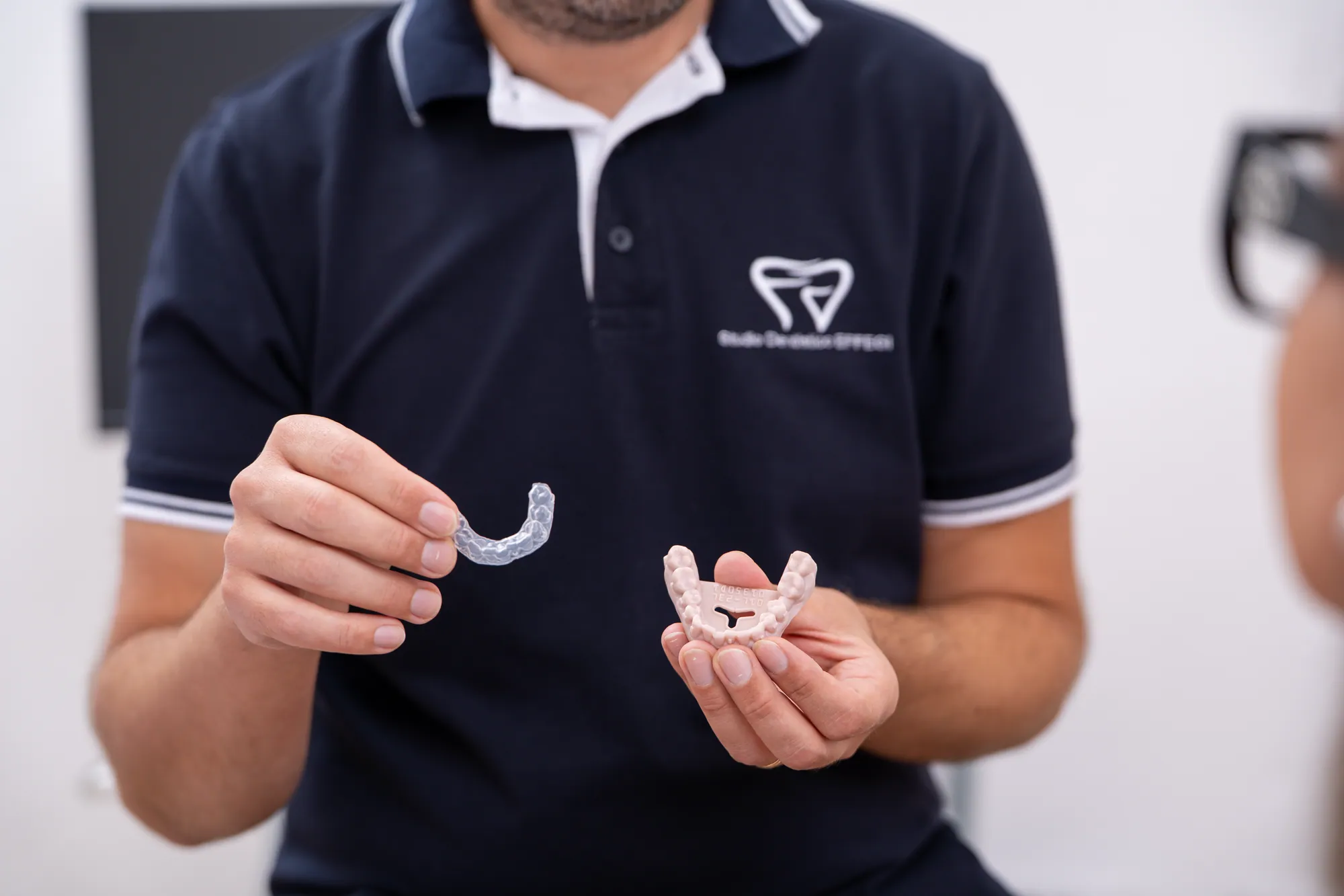 Il dentista mostra un allineatore trasparente e il modello dell'arcata